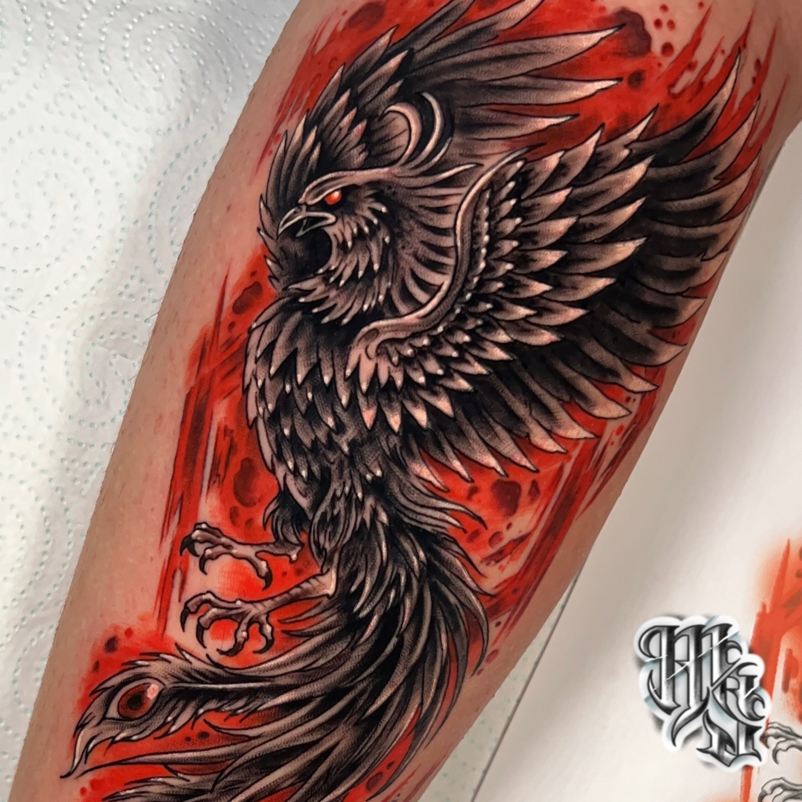 Tatuaje de fenix oscuro, con fondo rojo a todo color, estudio en madrid, vallecas, aluche y mostoles. miguel sierra tatuajes