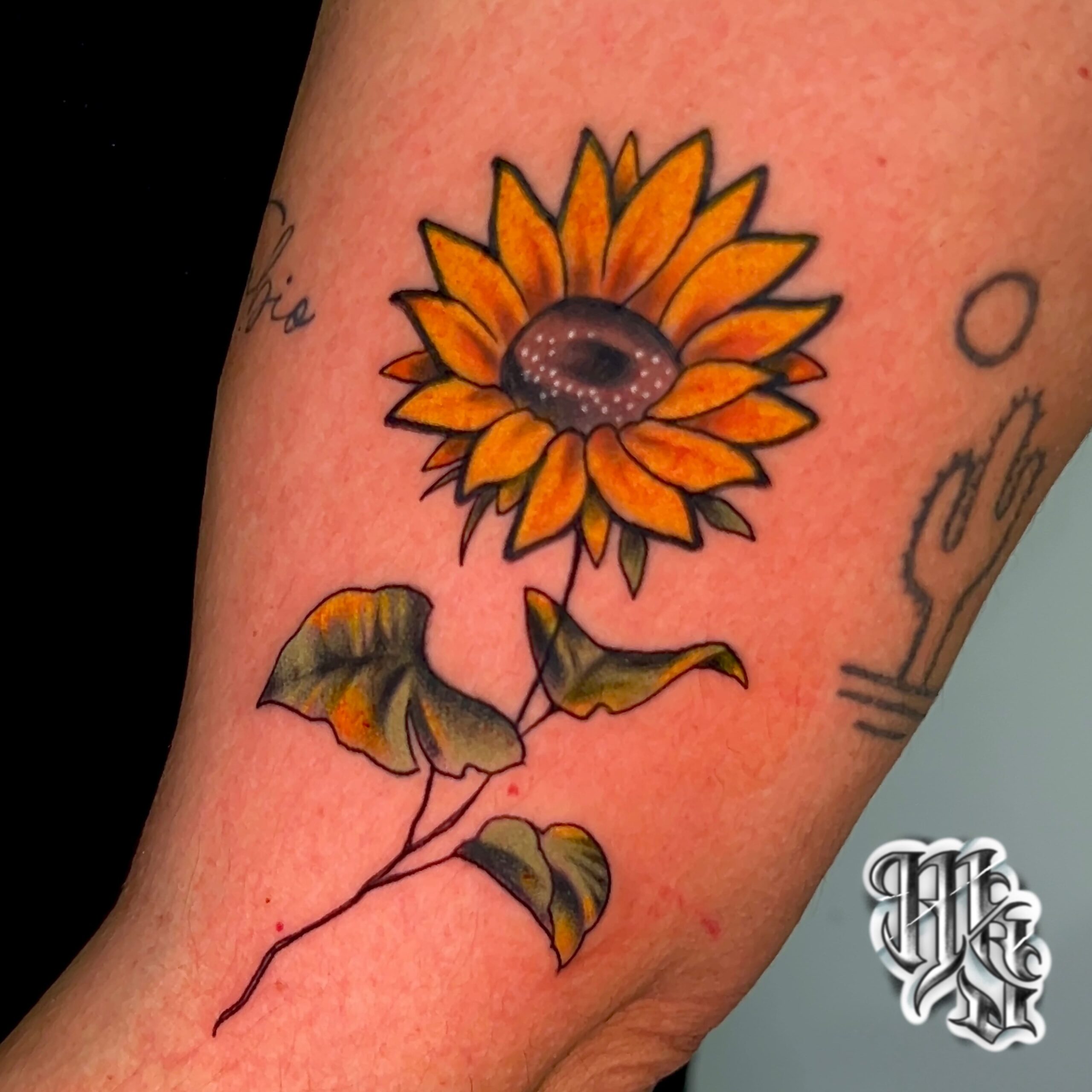 tatuaje delicado a color de un girasol realizado en estudio de tatuajes profesional en vallecas, aluche , mostoles madrid