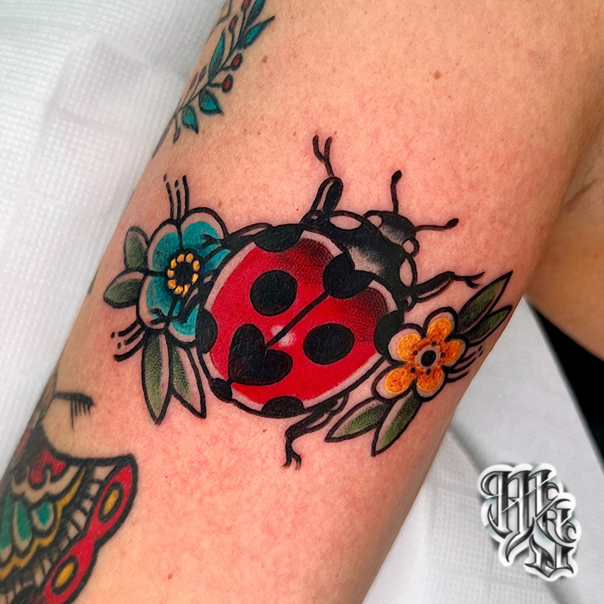 mariquita en estilo tradicional de tatuaje, oldschool y realizado en estudio de tatuajes profesional de madrid