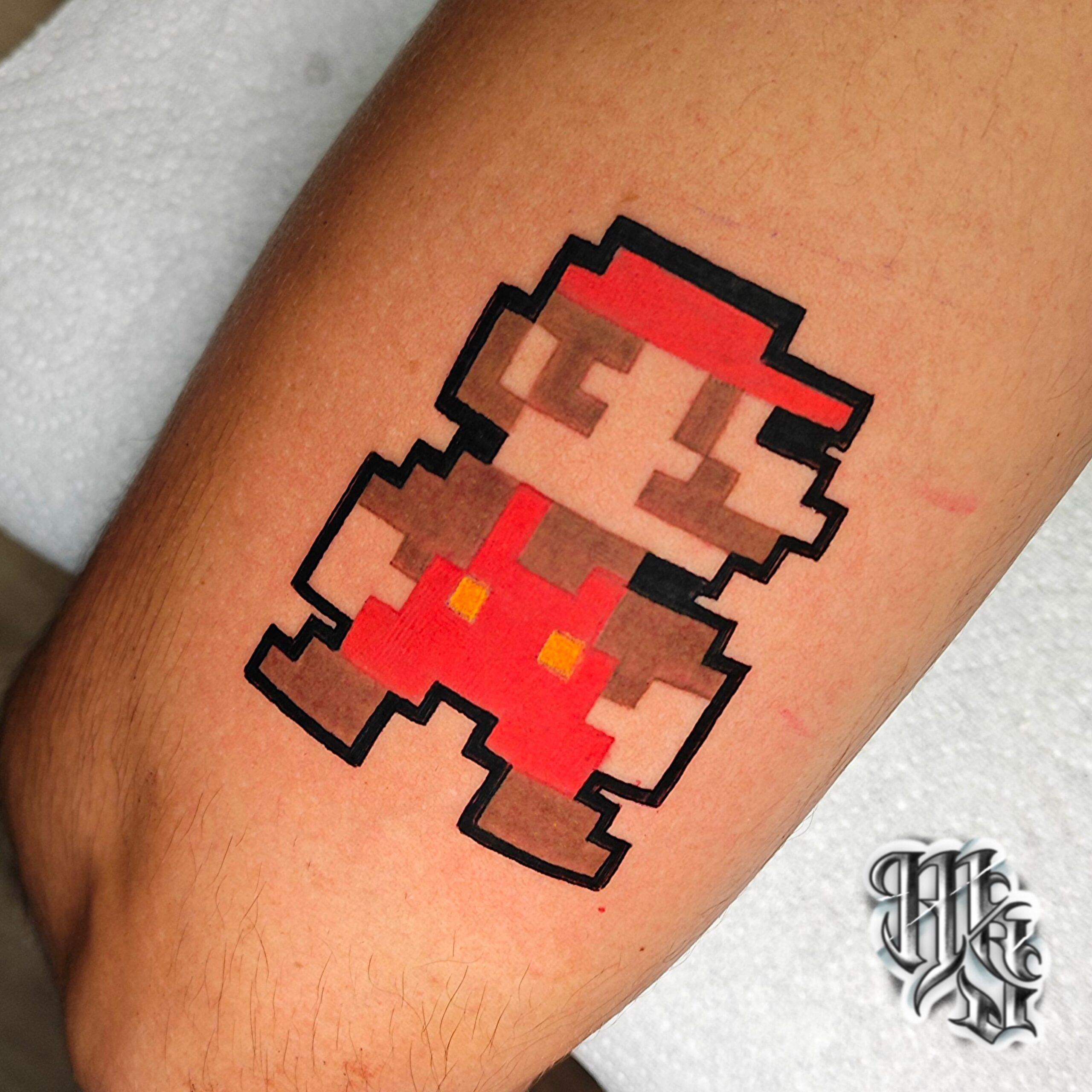 Tatuaje pixel de super mario bros en el estilo del primer video juego de los 80 , realizado en estudio de tatuajes de madrid
